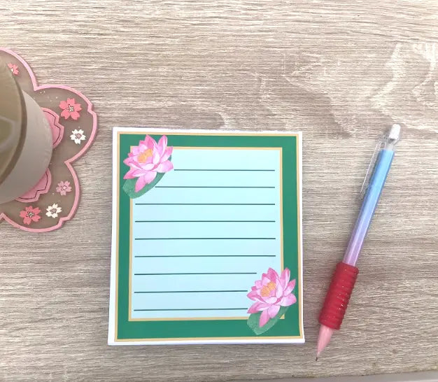Lotus design, 4.5 by 5.5 inch lined Memo Pad, Green page with dark green border, gold lining, one lotus in top left, one lotus in bottom right, not a sticky pad, Pyari Paper Shop