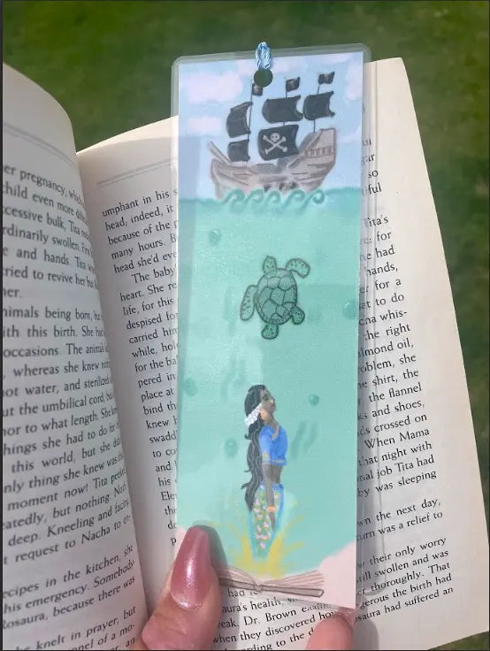 2 by 7 inch Bookmark, original art, Desi mermaid with a Sea Turtle swimming up to a pirate ship, seafoam green with blue sky, Mermaid with jasmine in her hair, wearing dark blue indian clothes, laminated, hole on edge to hold matching tassel,  Pyari Paper Shop