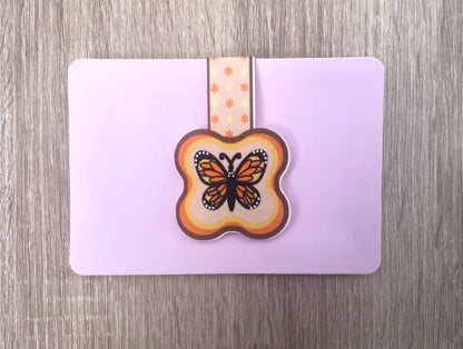 Monarch Butterfly, 2 by 3 inch Magnetic Bookmark on blush pink card packaging, Orange, yellow, black and white butterfly on light yellow background, orange and brown border, orange and yellow flowers, Pyari Paper Shop