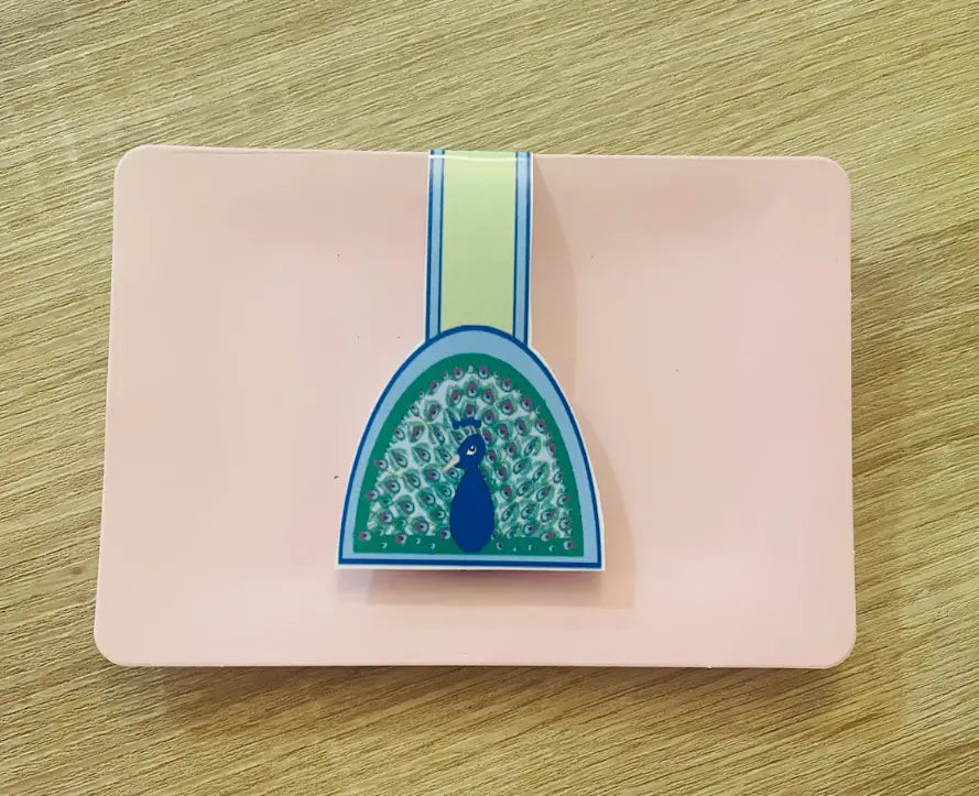 Peacock, 2 by 3 inch Magnetic Bookmark on pink card packaging, blue background, light green, light blue border, half moon shaped, peacock feathers, Pyari Paper Shop
